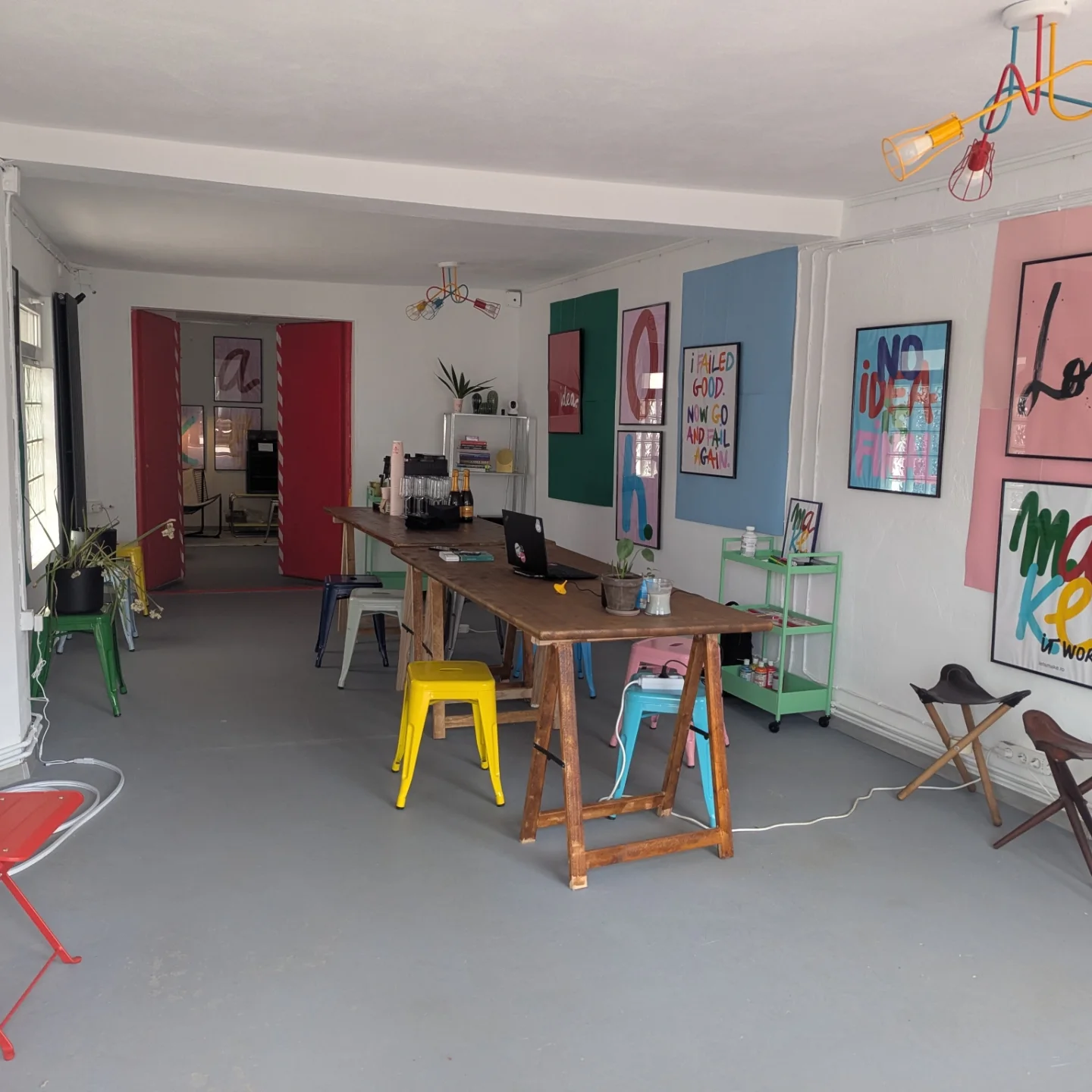 The main room seen from the entrance, with long tables, stools and poster walls